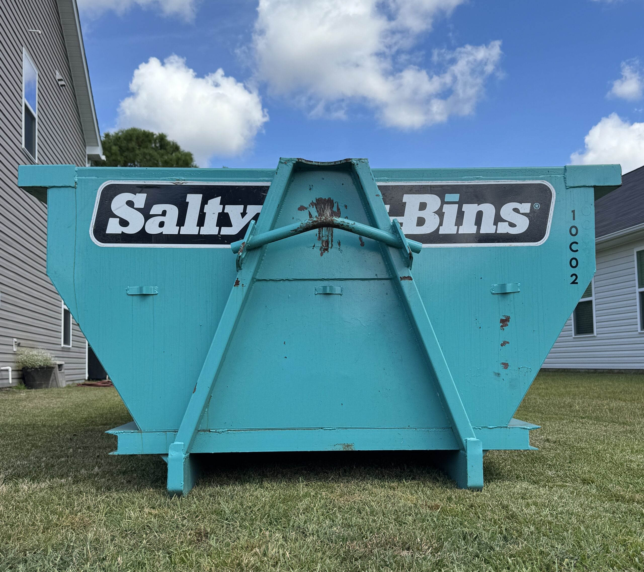Roll-off dumpster in the 10-yard size in Wilmington NC from Salty Bins, placed in the front lawn per client's request.